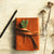 Leather journal with herbs on beige background